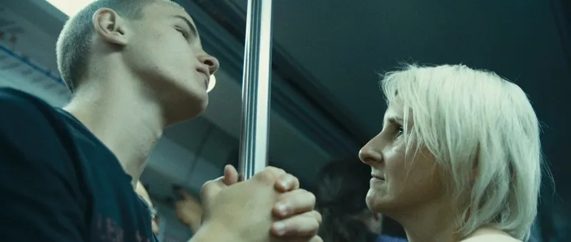 Monika Perkowska looks at her son Łukasz as they hold the same handrail